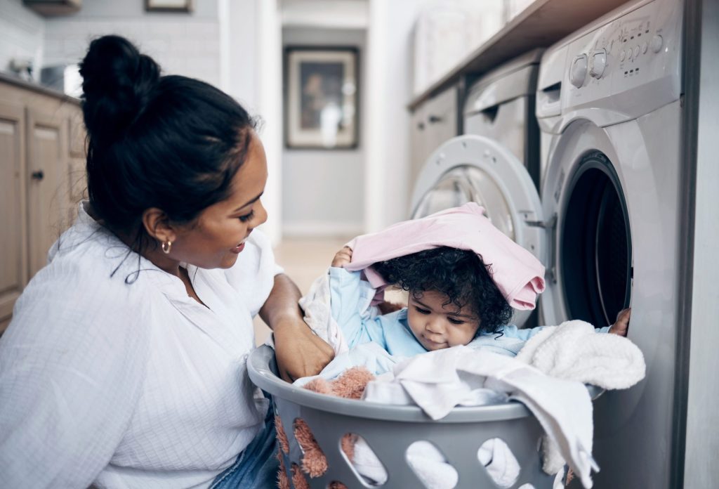 young mother playing with baby in laundry robertson family water